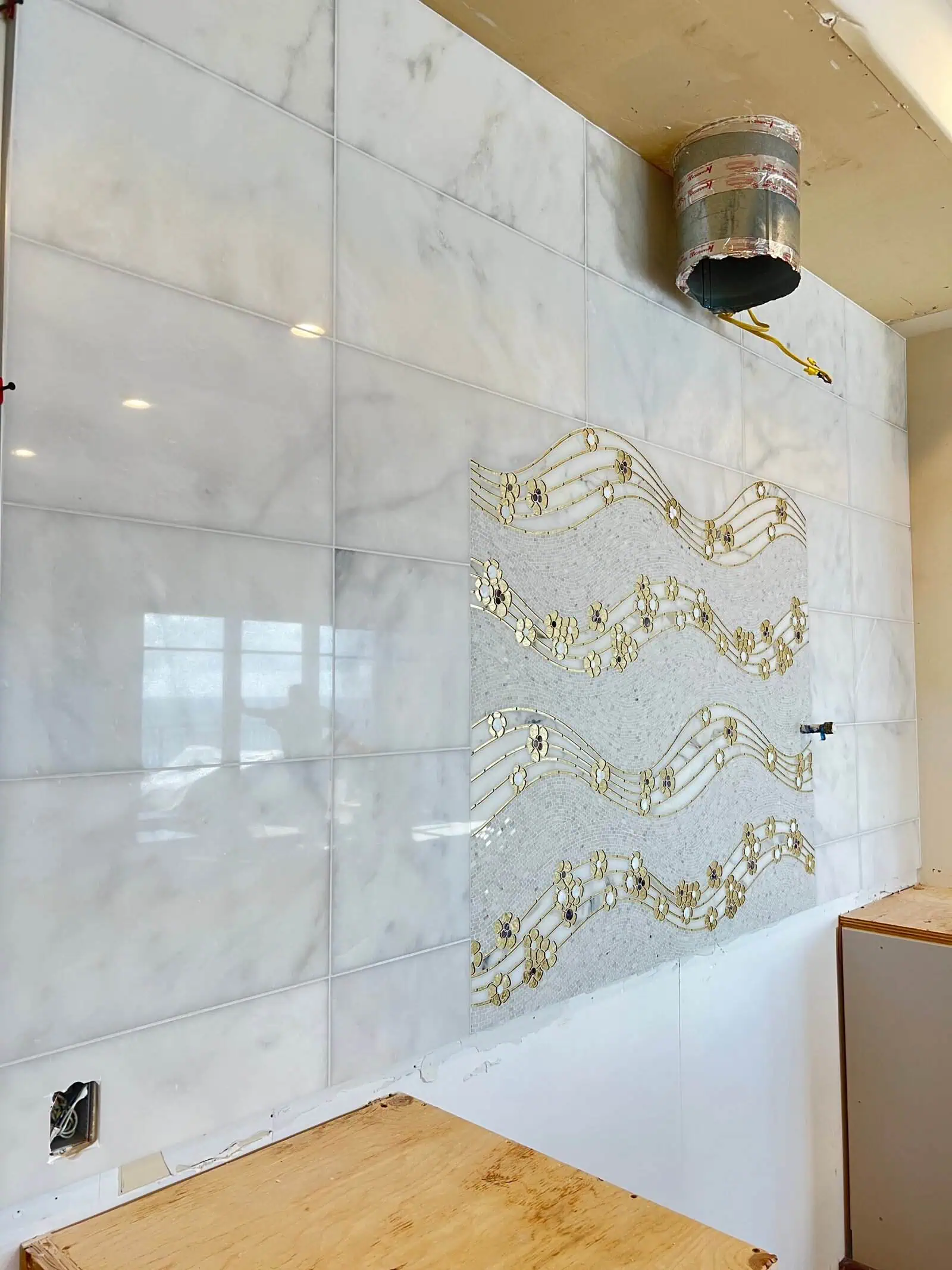 Beautiful marble wall with decorative metal musical note accents in a modern interior setting.